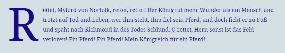 Ein Absatz mit etwas größerer blauer Schrift, grauem Hintergrund und einem Initialbuchstaben.